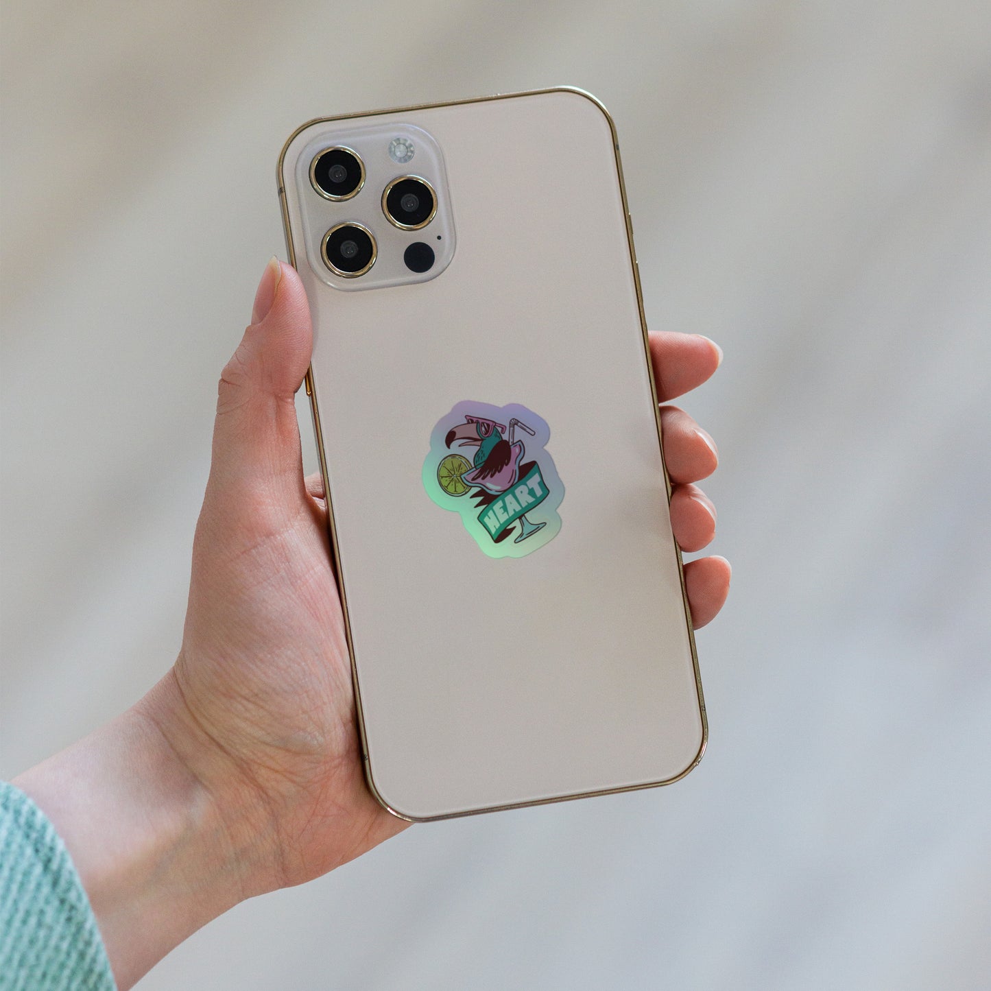 White iPhone with gold frame and holographic flamingo cocktail sticker